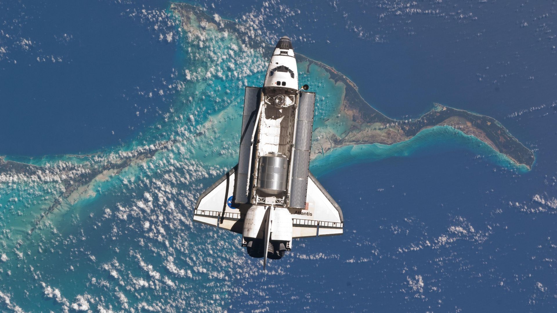 Photo of a space shuttle with an open cargo bay over the Bahamas