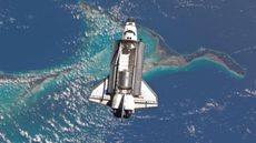 Photo of a space shuttle with an open cargo bay over the Bahamas 