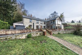large stone and oak frame house with stone garden steps and pathway