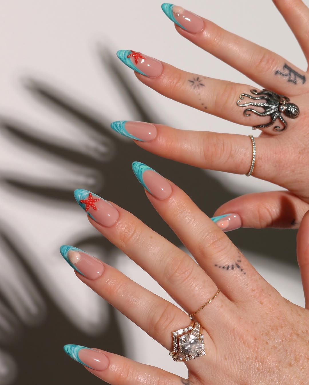 a blue french manicure with starfish and seashell designs