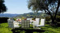 House of Leon wrought iron and boucle dining table and chair set pictured outside on the grass, overlooking the Los Angeles mountains