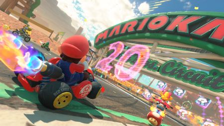 Mario performs a boost in Mario Kart World as he approaches a new circuit alongside other racers. The number '20' is lit up in front of them.
