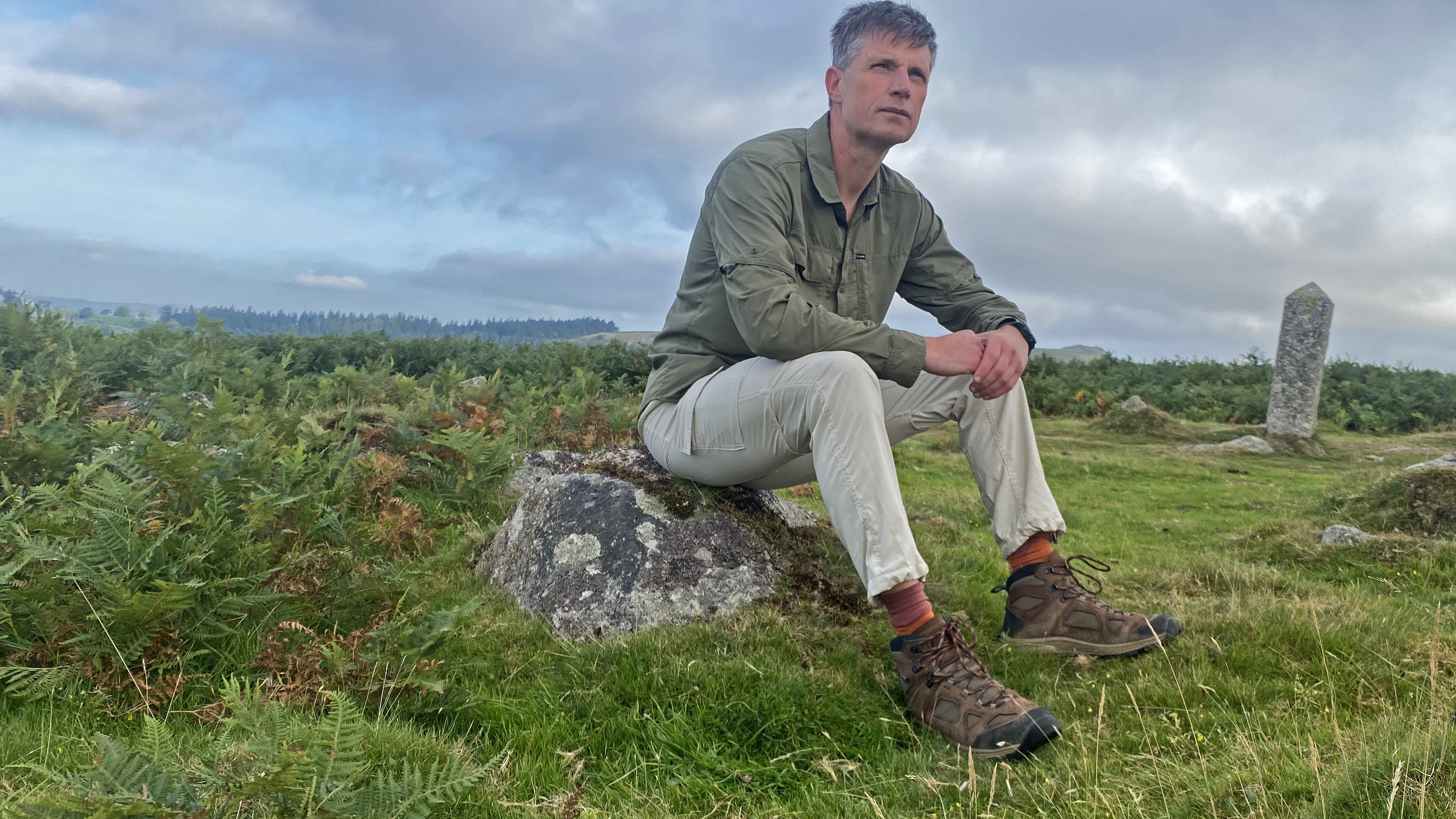 Hiker sitting on a boulder wearing the Columbia Skien Valley Cargo Hiking Trousers