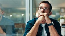 Young man in glasses looking stressed at work
