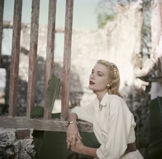 grace kelly posing against a door