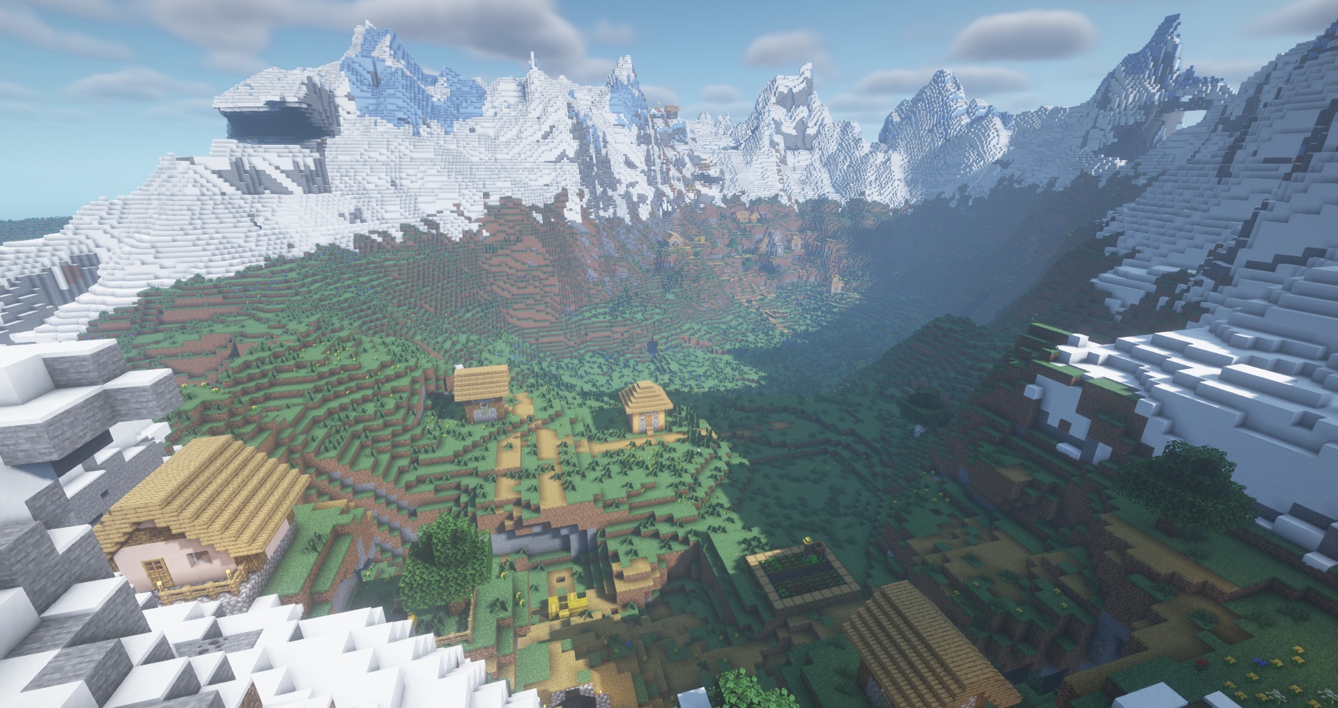 Minecraft screenshot with shaders showing a valley surrounded by snowy and icy mountains and two villages in the plains in between