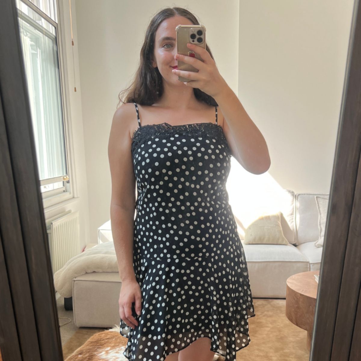 An image of Who What Wear UK fashion writer, Ava Gilchrist, wearing the viral M&amp;S polka-dot lace-trim slip dress. She is a size M and wears it in a size 10. 