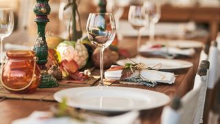 laid dinner table with plates and wine glasses