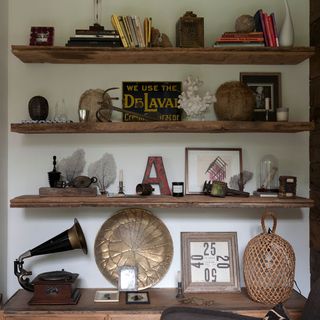 vintage wares and white wall with wooden shelves