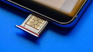 A close up of a SIM being placed into a tray slot on a smartphone