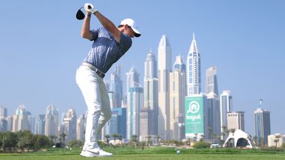 Rory McIlroy tees off on the eighth hole with the Dubai sky-line in the distance during the final round of the Hero Dubai Desert Classic at Emirates Golf Club