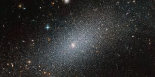 In a deep-space image featuring countless distant galaxies of all shapes and sizes, a tiny dwarf galaxy takes center stage. The small elliptical galaxy in the foreground of this new Hubble Space Telescope image is known as PGC 29388. It contains between 100 million to a few billion stars, which pales in comparison to our Milky Way galaxy, which has 250 to 400 billion stars. Hubble scientists released this image of PGC 29388 on April 20, a few days before the telescope celebrated its 30th anniversary.