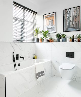 White marble bathroom with shelf built for keeping plants on