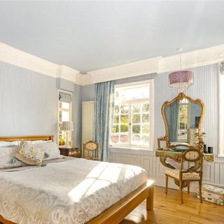 blue bedroom with wooden flooring and bed