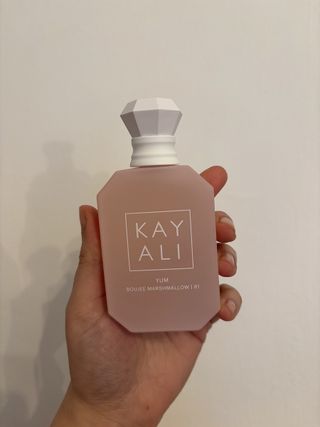 Mica Ricketts holding bottle of Kayali Yum Boujee Marshmallow | 81 Eau de Parfum