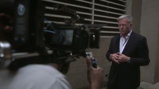 Chris Hansen looking at a TV camera in Predators.