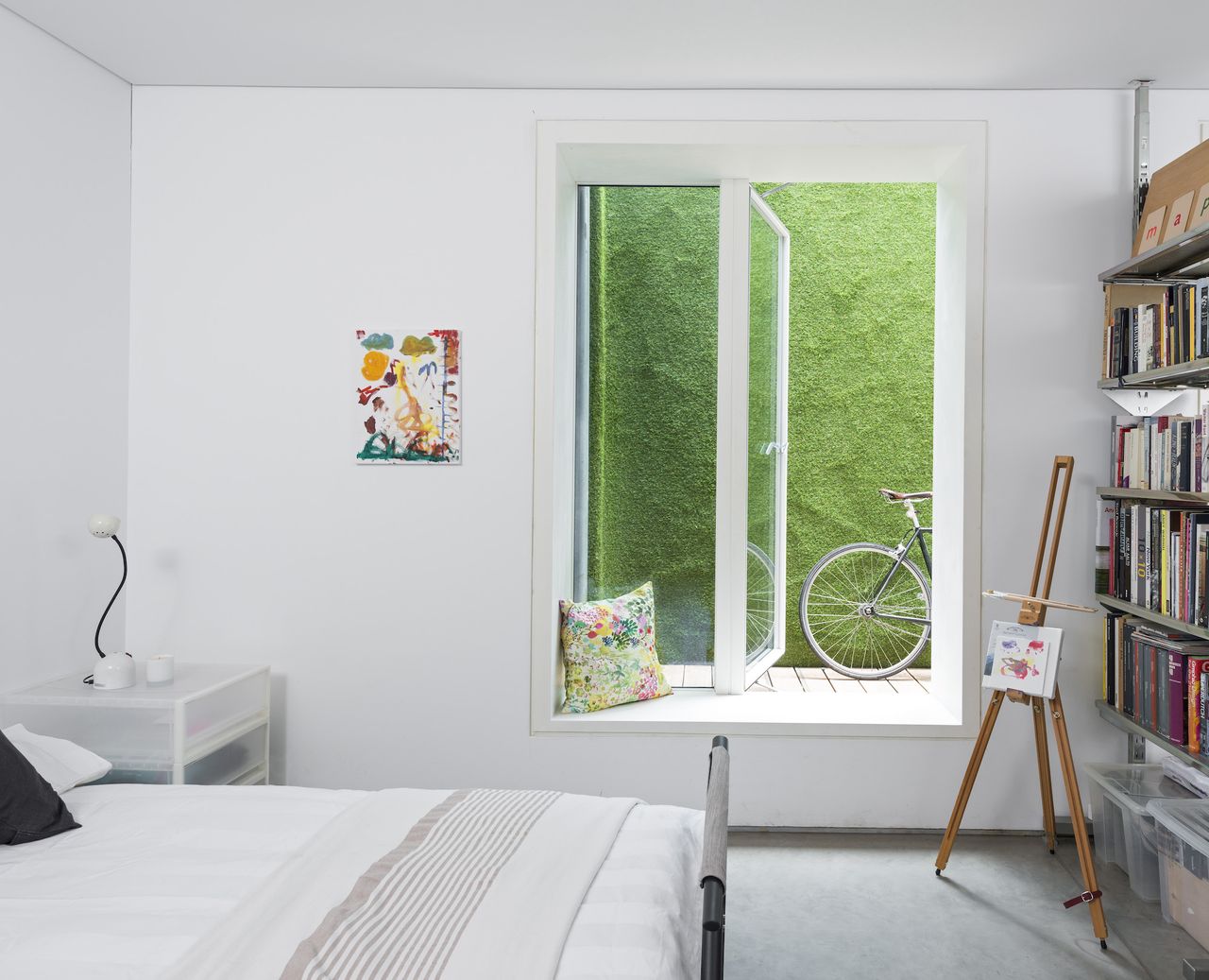 white bedroom with open window and bookcase