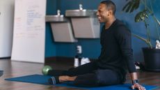 Man doing hip stretches in a yoga class