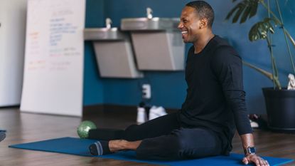 Man doing hip stretches in a yoga class