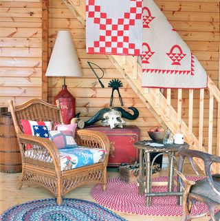 wooden staircase and living room with wooden furniture and patchwork throws and cushions