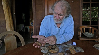 The late Mike Morwood in 2009 examines stone artifacts collected near Talepu.