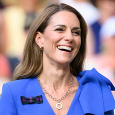 Kate Middleton laughing and wearing a blue dress at Wimbledon