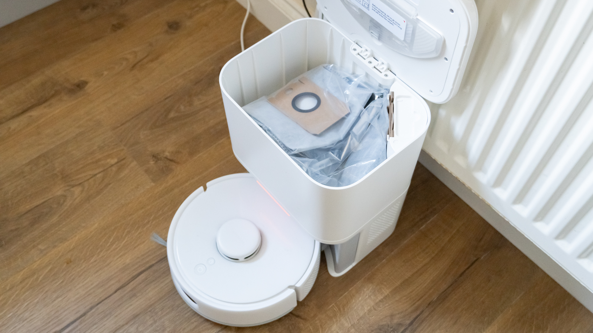 SwitchBot K10+ Pro mini robot vacuum dock, open to show dust bag inside