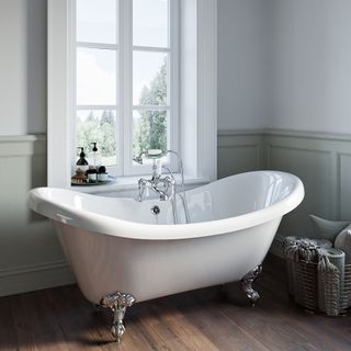 Freestanding Double Ended Roll Top Bath with Chrome Feet in front of window