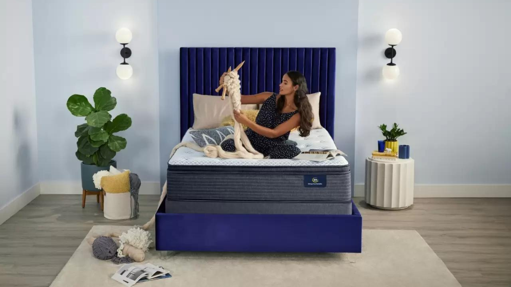 Lady playing with yarn on a Serta mattress in her bedroom