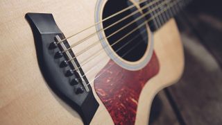 Close up of the bridge and strings on a Taylor GS Mini acoustic guitar