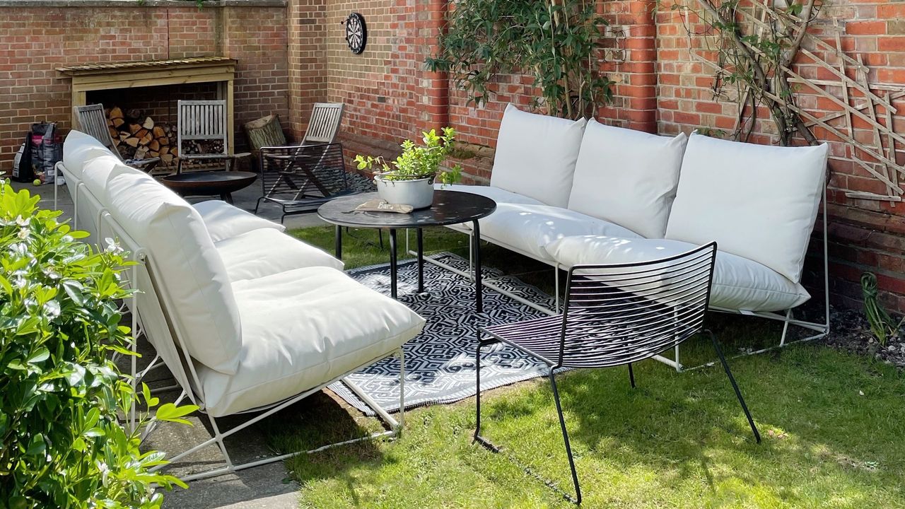 A sunny garden with two 3-seater IKEA HAVSTEN outdoor sofas facing each other