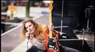 Billy corgan reclines against a wedge monitor with his orange/red modded Strat during a 1992 performance at Rock Torhout Festival, Netherlands