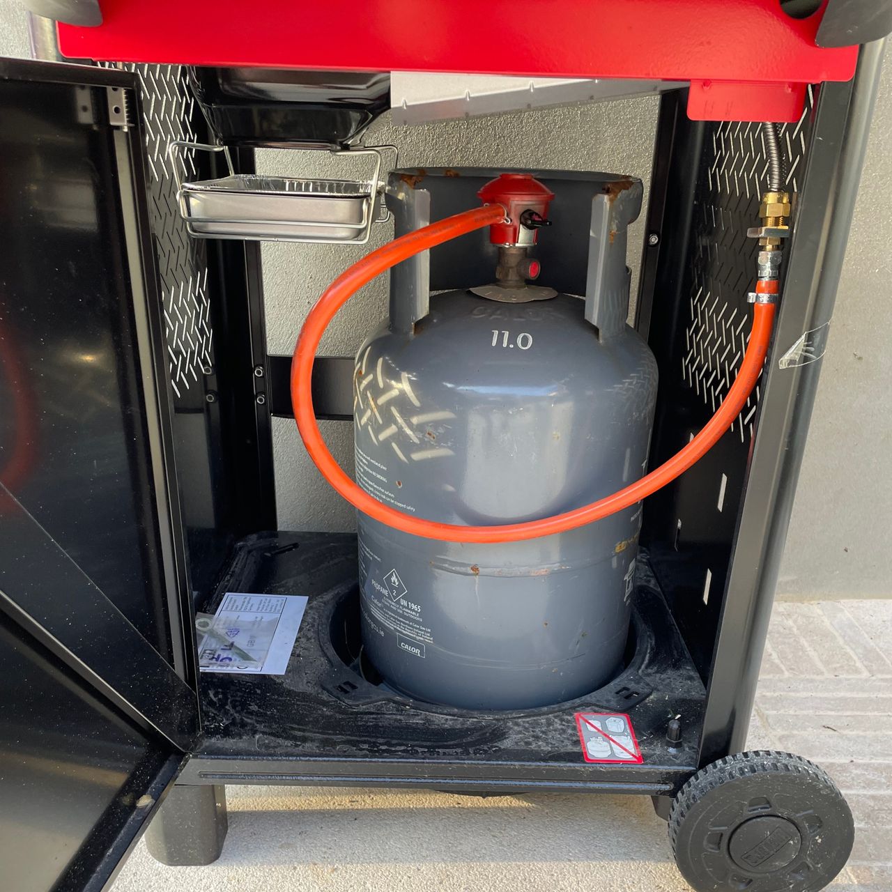 gas canister in the weber spirit e310 bbq in a garden