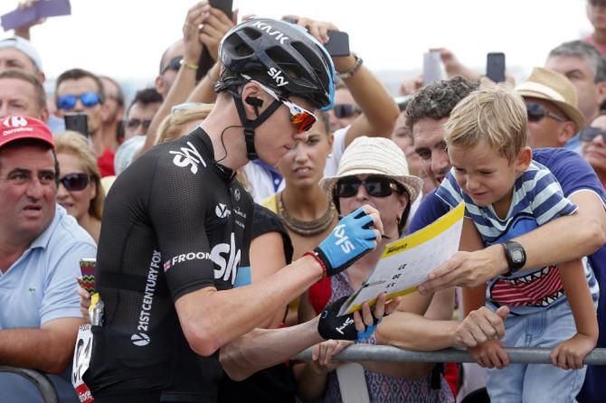 Chris Froome gives a few fans some autographs