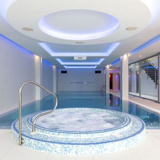 swimming pool with white wall and jacuzzi