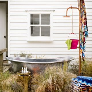 garden area with bathtub and garden shower and beach towels
