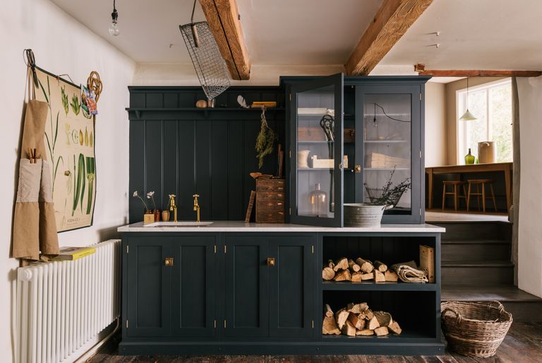 laundry closet in a room with dark painted cabinetry, log store, cupboards 