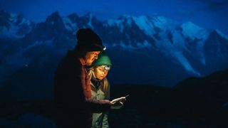 what to do if you get lost hiking: hiking couple at night looking at phone