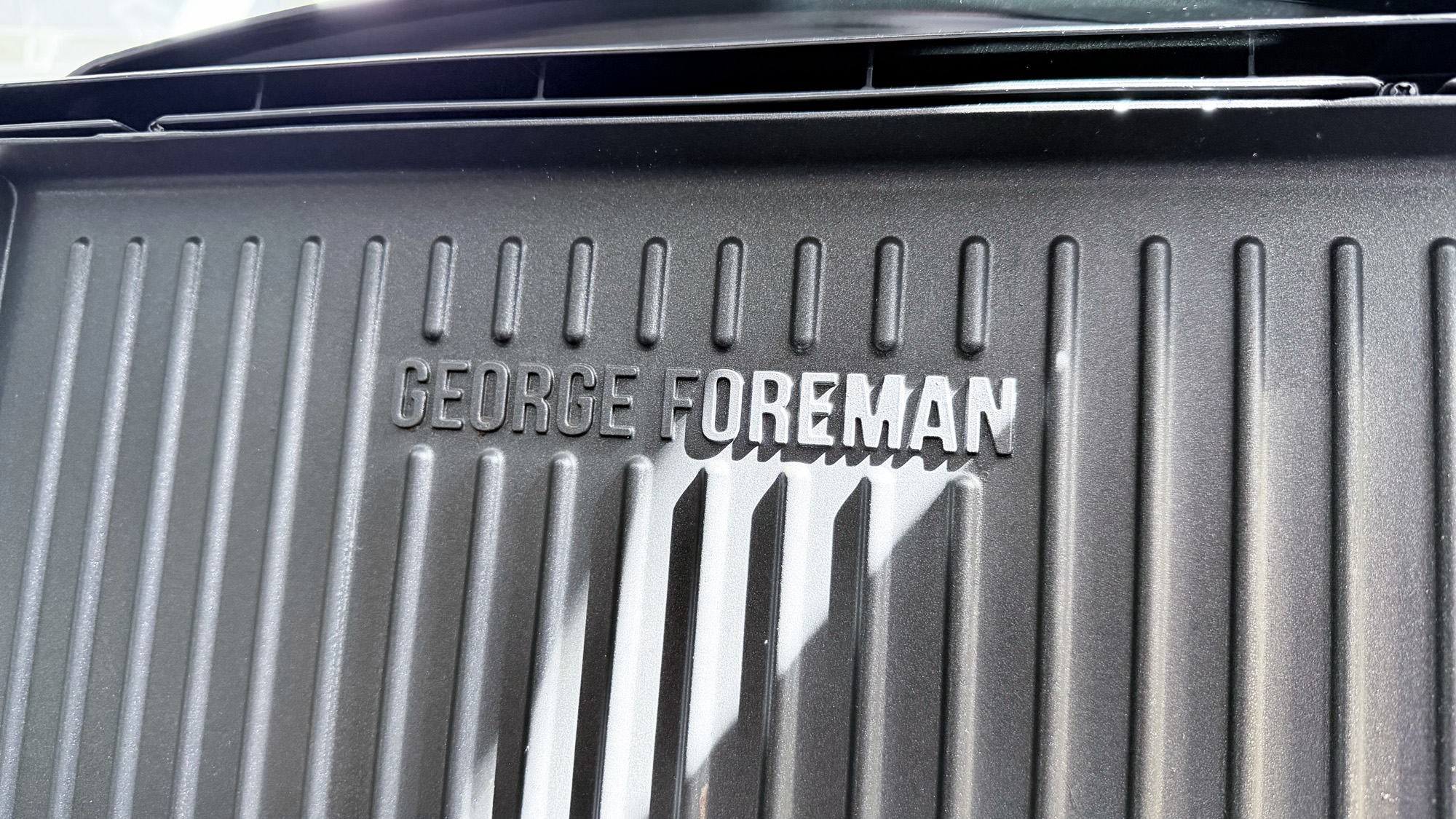 The George Foreman grill open and showing the logo