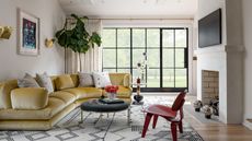 Living room with large windows and yellow curved velvet couch