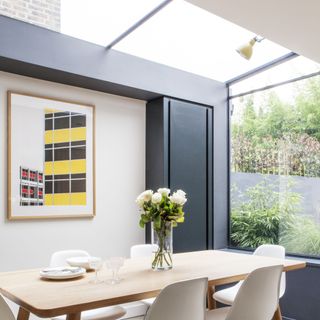 Skylight and glass window in grey and white kitchen with dining table