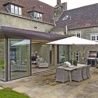 country house patio with contemporary garden room with outdoor dining table