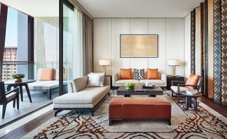 Living room with rug, low-slung chairs, sofa and floor to ceiling glass