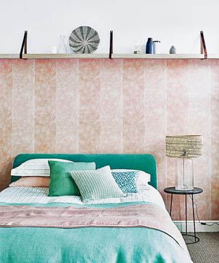 pink bedroom with striped wallpaper and wall shelf
