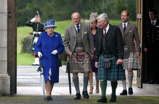 Queen Elizabeth II, Prince Philip, Duke of Edinburgh, Sophie, Countess of Wessex, and Prince Edward, Earl of Wessex, walk together during a garden party at Balmoral Castle