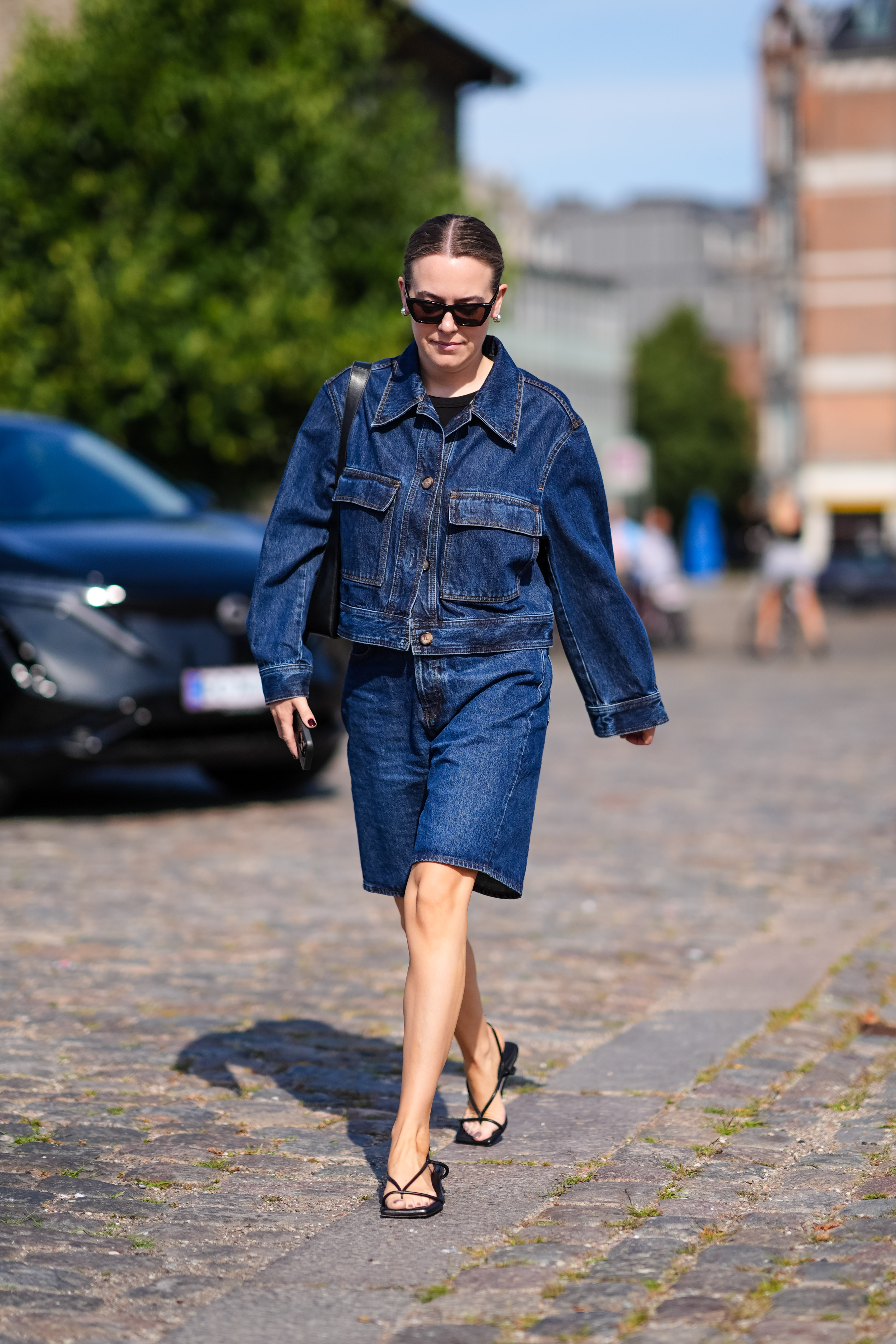 woman wearing denim jacket, denim shorts, and strappy sandals