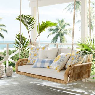The Springwood Hanging Daybed on a veranda by the sea