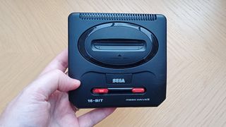 Sega Mega Drive Mini 2 review; a person holds a small games console