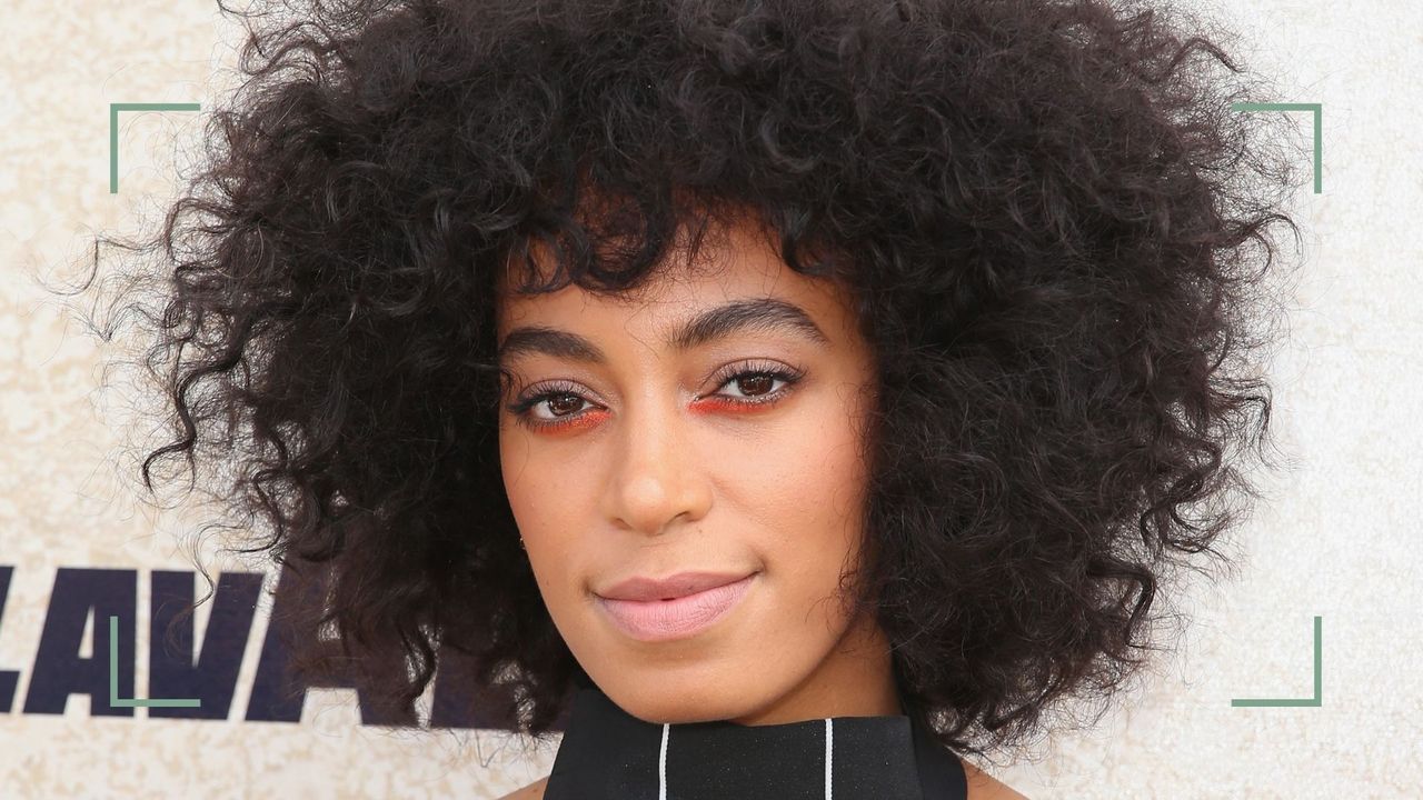 Solange Knowles wearing bright eyeshadow looks, with orange eyeshadow on the lower lash line