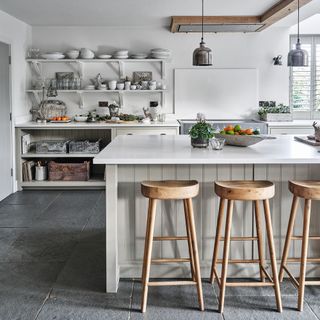 kitchen with grey floor and white breakfast bar with stools